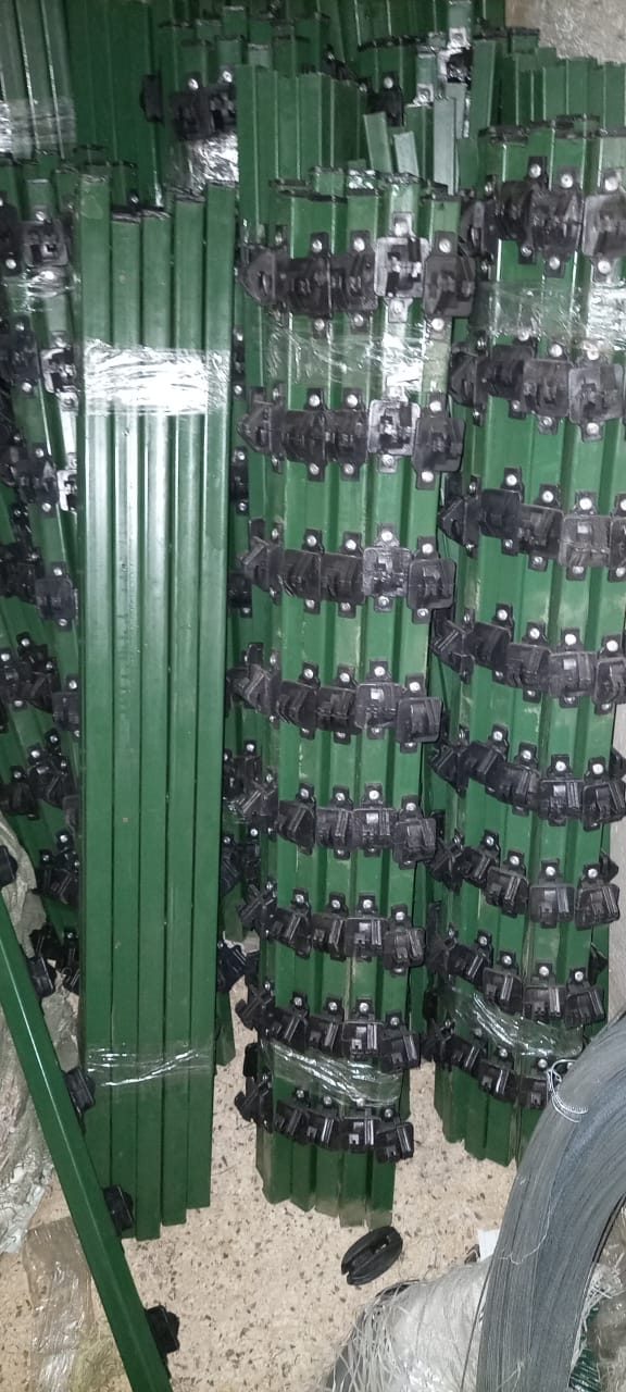 Green electric fence corner posts with insulators, bundled in stock